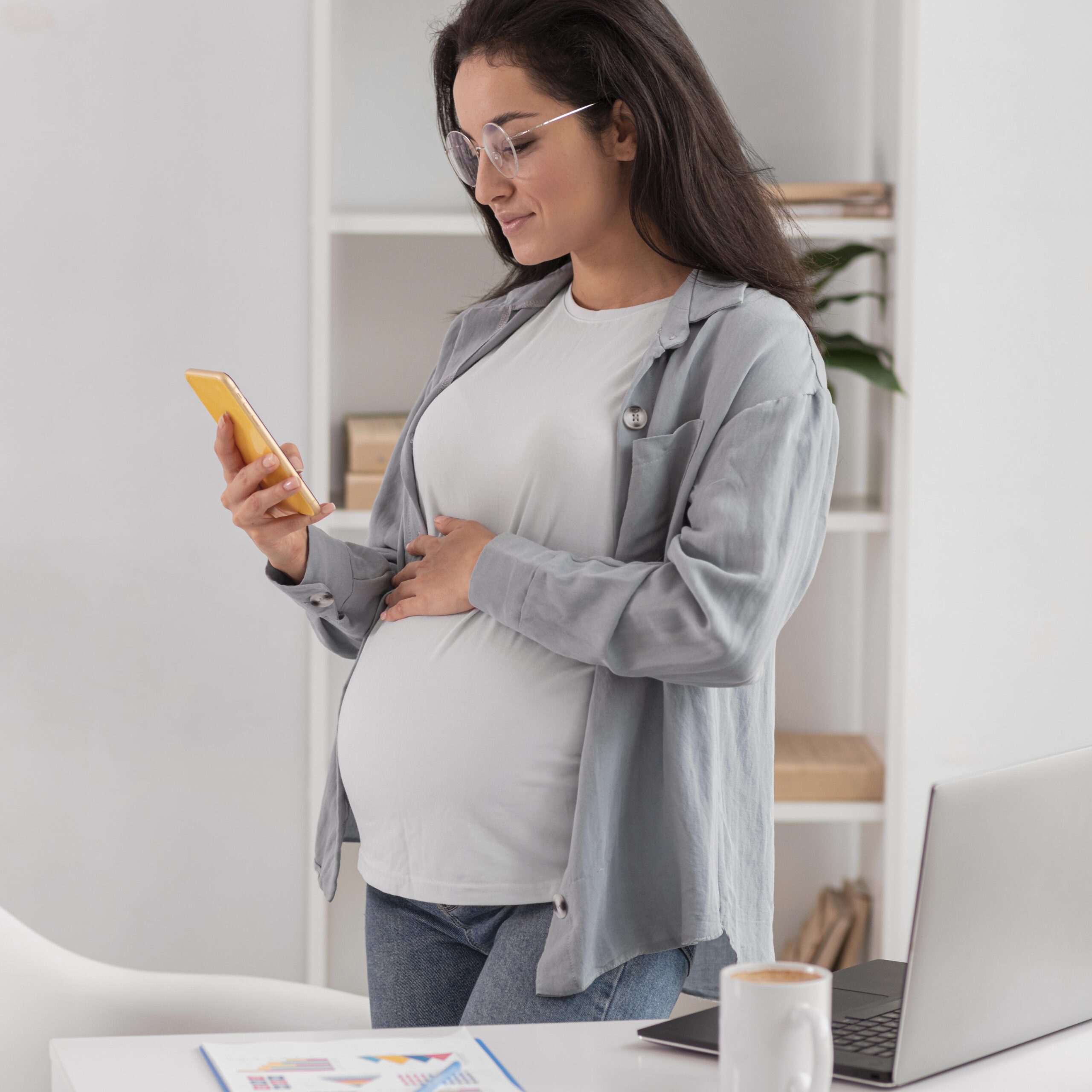side-view-pregnant-woman-home-with-laptop-smartphone